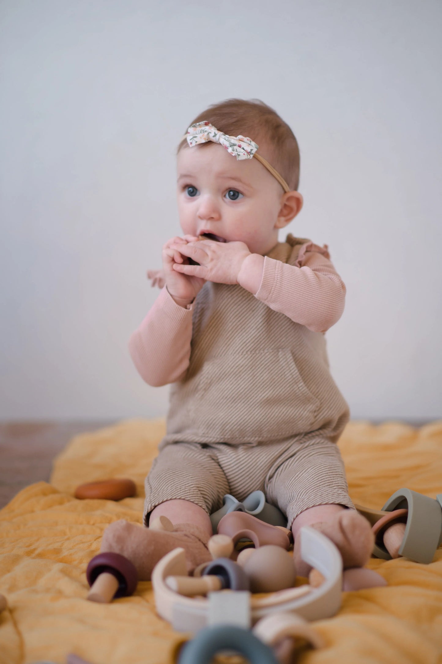 Toddler stacking rainbow arches on cotton play mat